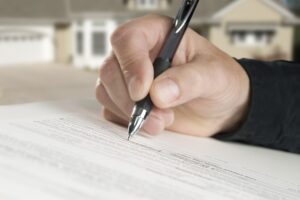 Trust Lawyer Brandon, FL with a close up view of a hand holding a pen signing a document